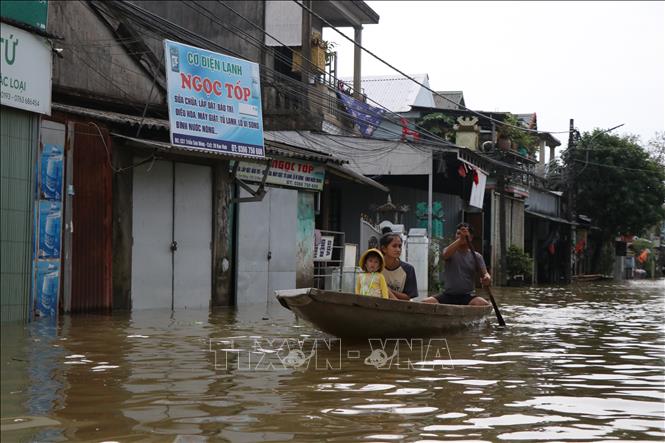 Người dân di chuyển bằng ghe qua các con đường. Ảnh: Mai Trang- TTXVN 