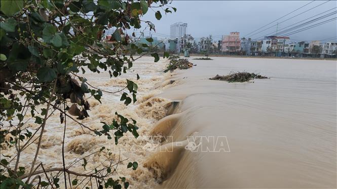 Tuyến giao thông trên đập tràn phường Quy Nhơn Đông bị nước nhấn chìm. Ảnh: Sỹ Thắng - TTXVN             