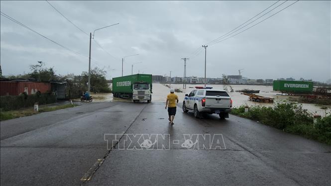 Lực lượng cảnh sát trực tại tuyến đường bị ngập để phân luồng giao thông. Ảnh: Sỹ Thắng-TTXVN