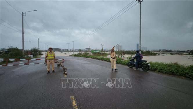 Lực lượng cảnh sát giao thông phân luồng trên tuyến đường bị ngập. Ảnh: Sỹ Thắng-TTXVN