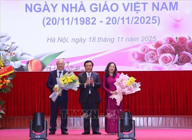 GS,TS Nguyễn Xuân Thắng tặng hoa chúc mừng hai tân giáo sư. Ảnh:Văn Điệp – TTXVN