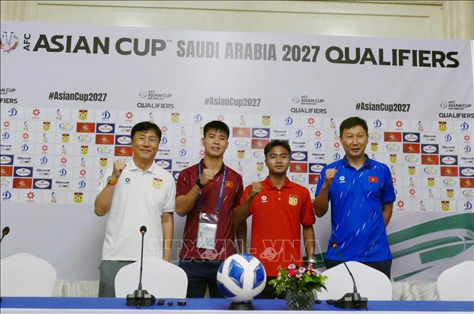 HLV và Đội trưởng hai đội Việt Nam-Lào chụp ảnh chung thể hiện quyết tâm thi đấu trên cơ sở đoàn kết. Ảnh: Xuân Tú - PV TTXVN tại Lào