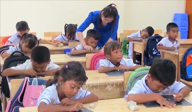Cô giáo Nèang Lai My hướng dẫn từng học sinh từ nét chữ đầu tiên. Ảnh: Công Mạo-TTXVN