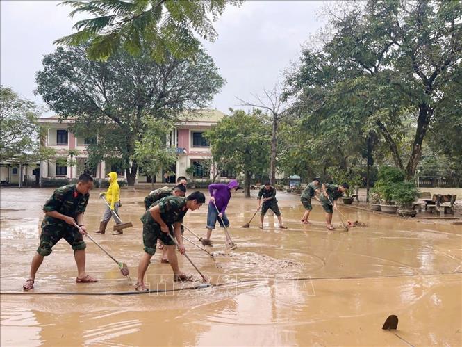Gần 100 cán bộ, chiến sĩ Trung đoàn Bộ binh 842 và Ban Chỉ huy Quân sự xã Triệu Phong (Bộ Chỉ huy Quân sự tỉnh QUảng Trị) tích cực hỗ trợ địa phương khắc phục hậu quả mưa lũ. Ảnh: TTXVN phát