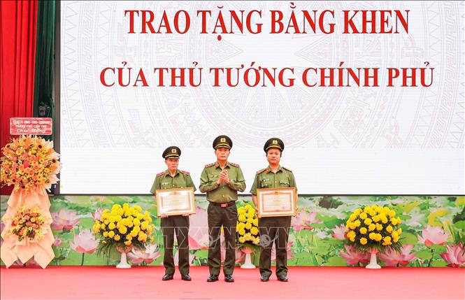 Thượng tướng Lê Quốc Hùng, Thứ trưởng Bộ Công an chúc mừng 1 tập thể và 1 cá nhân được nhận Bằng khen của Thủ tướng Chính phủ. Ảnh: TTXVN phát