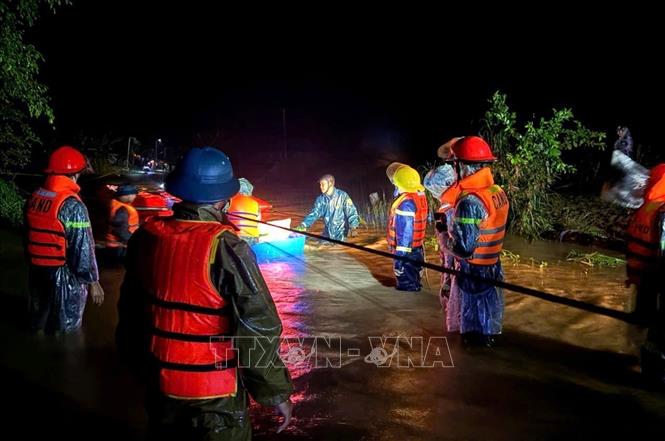 Lực lượng chức năng xã Yang Mao di dời các hộ dân vùng ngập lụt đên nơi an toàn trong đêm. Ảnh: TTXVN phát