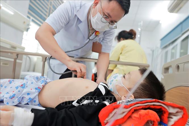 Bác sĩ khám cho bệnh nhi mắc cúm A đang điều trị tại Bệnh viện Bệnh nhiệt đới Trung ương. Ảnh: Minh Quyết - TTXVN