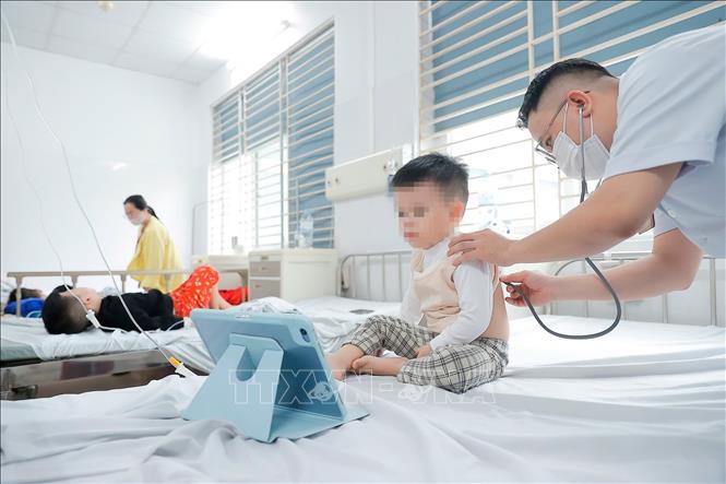 Bác sĩ khám cho bệnh nhi mắc cúm A đang điều trị tại Bệnh viện Bệnh nhiệt đới Trung ương. Ảnh: Minh Quyết - TTXVN