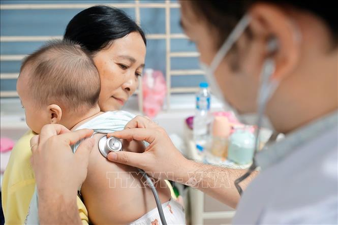 Bác sĩ khám cho bệnh nhi mắc cúm A đang điều trị tại Bệnh viện Bệnh nhiệt đới Trung ương. Ảnh: Minh Quyết - TTXVN