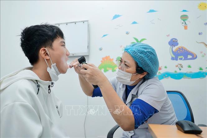 Bác sĩ khám cho bệnh nhân khi có triệu chứng mắc cúm. Ảnh: Minh Quyết - TTXVN