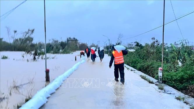 Lực lượng vũ trang tỉnh Gia Lai vận chuyển bao cát, đắp đập tạm tại các điểm xung yếu. Ảnh: TTXVN phát