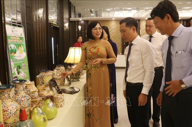 Phó Chủ tịch UBND tỉnh Đồng Nai Nguyễn Thị Hoàng giới thiệu sản phẩm gốm Biên Hòa cho các đại biểu đến từ các tỉnh Đồng bằng sông Cửu Long. Ảnh: Lê Xuân-TTXVN