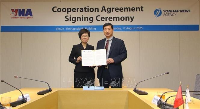 Tổng Giám đốc TTXVN Vũ Việt Trang và Chủ tịch Yonhap Hwang Dae Il trao đổi Thỏa thuận hợp tác nghiệp vụ trong giai đoạn mới tập trung vào chuyển đổi số và ứng dụng công nghệ trí tuệ nhân tạo trong lĩnh vực thông tin, truyền thông (12/8/2025). Ảnh: Đức Thắng - TTXVN