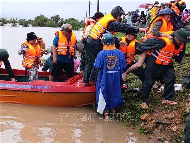 Lực lượng vũ trang tỉnh Gia Lai nỗ lực giúp dân di dời khỏi vùng ngập lụt. Ảnh: Sỹ Thắng - TTXVN 
