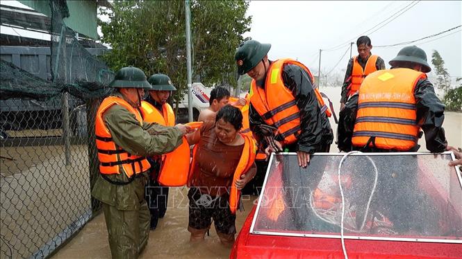 Lực lượng vũ trang tỉnh Gia Lai nỗ lực giúp dân di dời khỏi vùng ngập lụt. Ảnh: Sỹ Thắng - TTXVN 