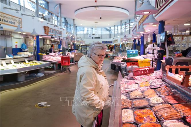 Người tiêu dùng mua sắm tại chợ ở Manchester, Anh. Ảnh: THX/TTXVN