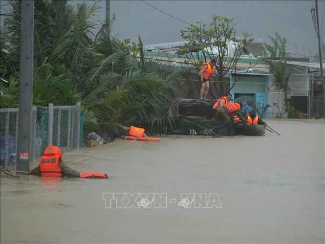Lực lượng vũ trang tỉnh Gia Lai nỗ lực giúp dân di dời khỏi vùng ngập lụt. Ảnh: Sỹ Thắng - TTXVN
