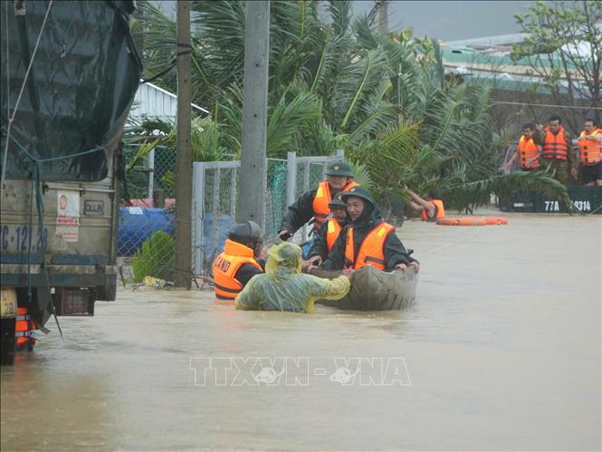 Lực lượng vũ trang tỉnh Gia Lai nỗ lực giúp dân di dời khỏi vùng ngập lụt. Ảnh: Sỹ Thắng - TTXVN 