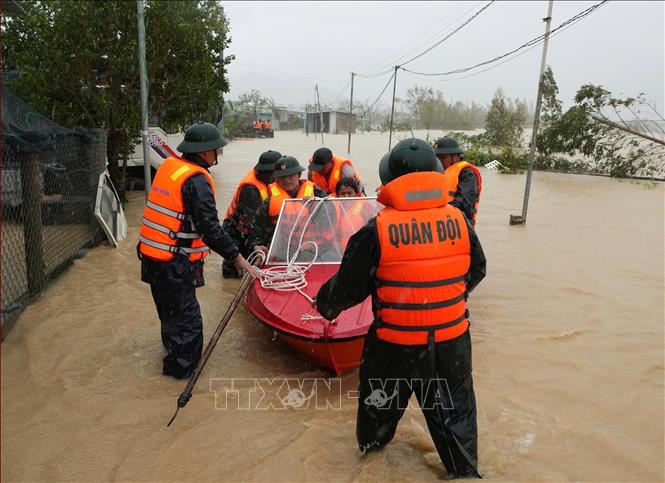Lực lượng vũ trang tỉnh Gia Lai nỗ lực giúp dân di dời khỏi vùng ngập lụt. Ảnh: Sỹ Thắng - TTXVN 