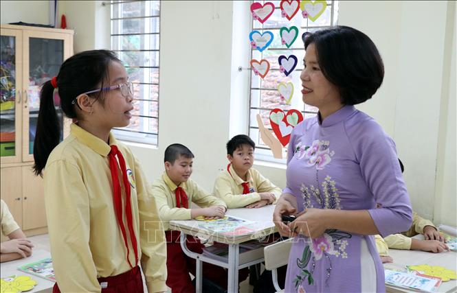 Cô giáo Phạm Thị Hoa Trường Tiểu học Phạm Hồng Thái (phường Nam Định) trao đổi  với học sinh trong giờ học. Ảnh: Nguyễn Lành - TTXVN 
