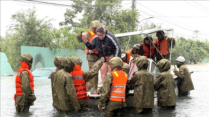 Công an dùng ca nô ứng cứu người dân phường Tuy Hoà bị ngập lũ. Ảnh: Tường Quân - TTXVN