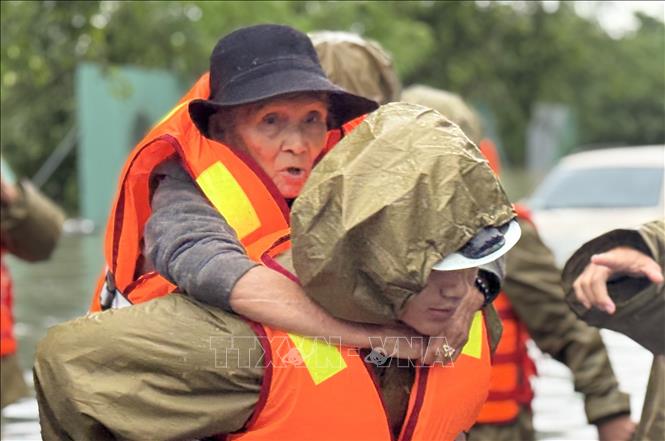 Di dời kịp thời một người già phường Tuy Hoà đến nơi an toàn. Ảnh: Tường Quân - TTXVN