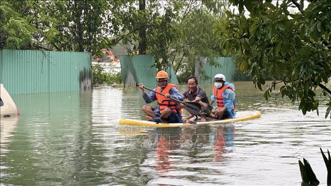 Dùng chèo súp chở người dân đến nơi an toàn. Ảnh: Tường Quân - TTXVN