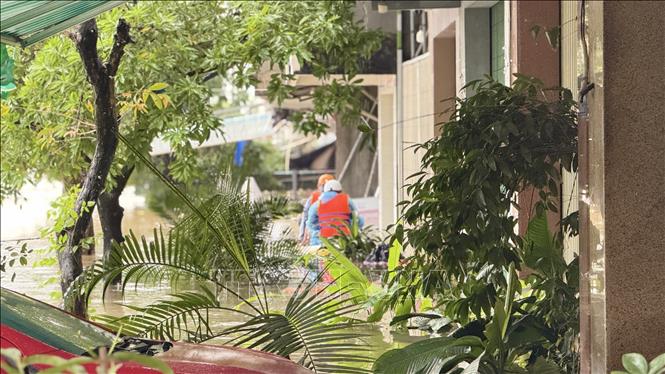 Dùng chèo súp đến từng hộ dân ngập lụt. Ảnh: Tường Quân - TTXVN