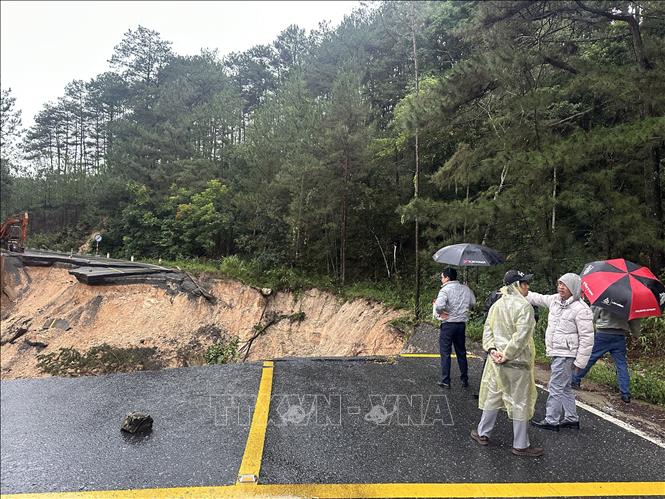 Cán bộ Sở Xây dựng tỉnh Lâm Đồng nghiên cứu phương án khắc phục tạm thời tuyến đèo bị sạt lở. Ảnh: Chu Quốc Hùng - TTXVN