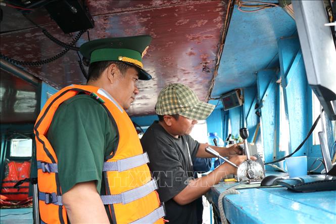 Chiến sĩ Đồn Biên phòng Long Vĩnh kiểm tra các thiết bị trên tàu cá tại Cảng cá Định An (xã Đại An, tỉnh Vĩnh Long). Ảnh: Thanh Hòa- TTXVN