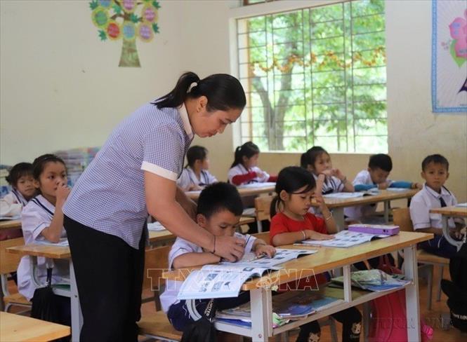 Cô giáo Lô Thị Bảo bên các học trò lớp 1 tại Điểm trường tiểu học khối bản Na Ngân, giữa đại ngàn Pù Huống, Tương Dương, Nghệ An. Ảnh: Xuân Tiến - TTXVN
