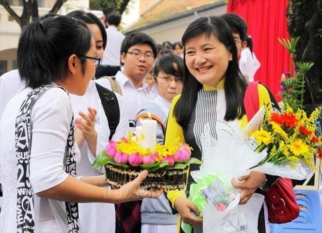 Học sinh trường THPT Chuyên Lê Hồng Phong (TP Hồ Chí Minh) tặng hoa chúc mừng cô giáo trong Ngày Nhà giáo Việt Nam 20/11. Ảnh: Phương Vy -TTXVN