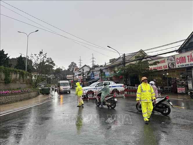Lực lượng chức năng ngăn chặn, cảnh báo từ đầu đèo Mimosa với các phương tiện định di chuyển qua đèo. Ảnh: Chu Quốc Hùng - TTXVN