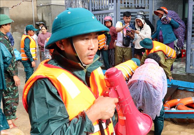 Các lực lượng cứu hộ rất khẩn trương vào thôn Phước Lợi (xã Ninh Phước) để đưa người dân bị mưa lũ cô lập đến nơi an toàn. Ảnh: Công Thử - TTXVN