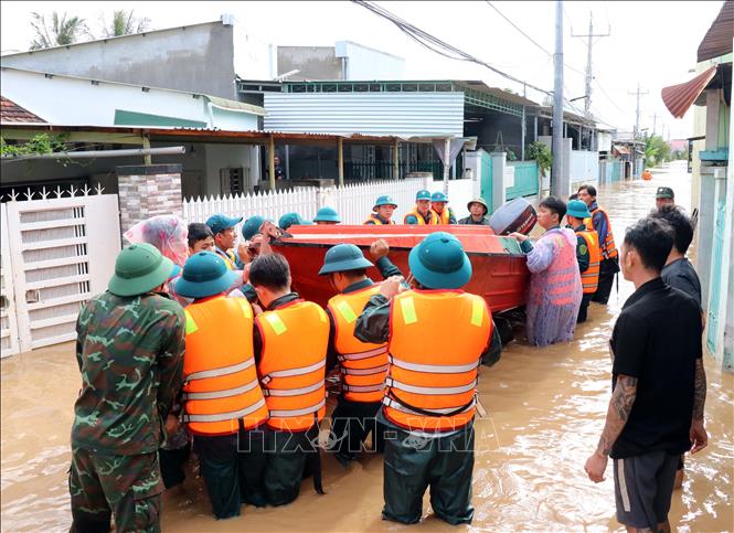 Các lực lượng cứu hộ khẩn trương đưa phương tiện vào thôn Phước Lợi (xã Ninh Phước) để đưa người dân bị mưa lũ cô lập đến nơi an toàn. Ảnh: Công Thử - TTXVN