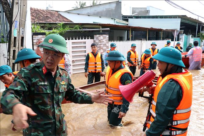 Các lực lượng cứu hộ khẩn trương đưa phương tiện vào thôn Phước Lợi (xã Ninh Phước) để đưa người dân bị mưa lũ cô lập đến nơi an toàn. Ảnh: Công Thử - TTXVN