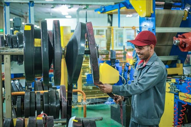 Công nhân sử dụng tăng dính dán biên thân lốp TBR ở máy cắt 90. Ảnh: Hoàng Hiếu - TTXVN