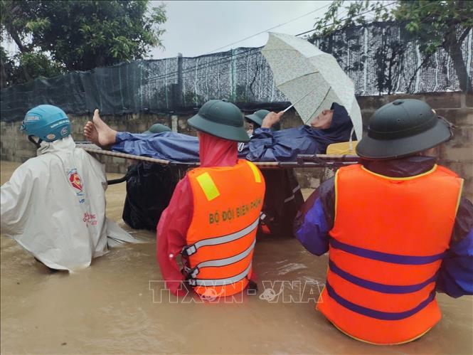 Bộ đội Biên phòng Gia Lai giúp dân di chuyển người già, yếu tránh lũ. Ảnh: TTXVN phát