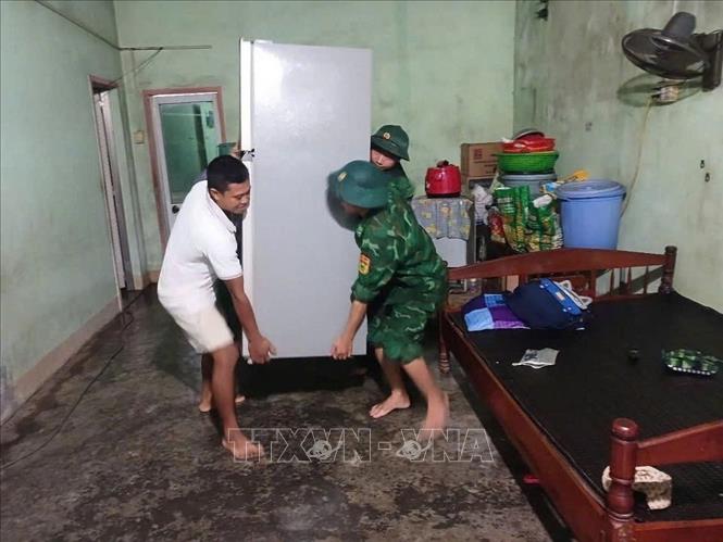Bộ đội Biên phòng Gia Lai giúp dân phường Hoài Nhơn Đông di chuyển tài sản tránh lũ. Ảnh: TTXVN phát