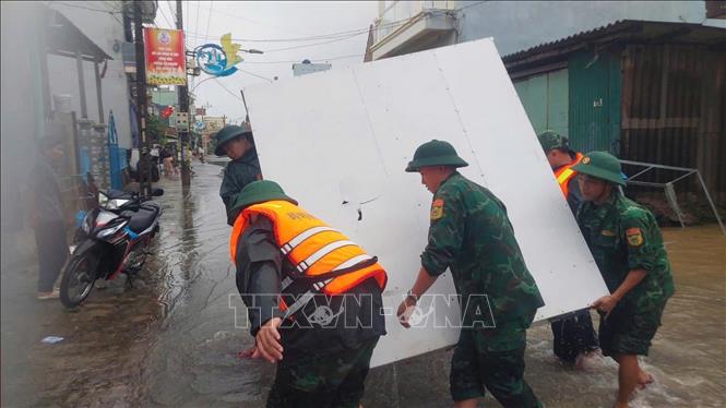 Bộ đội Biên phòng Gia Lai giúp dân phường Hoài Nhơn Đông di chuyển tài sản tránh lũ.  Ảnh: TTXVN phát