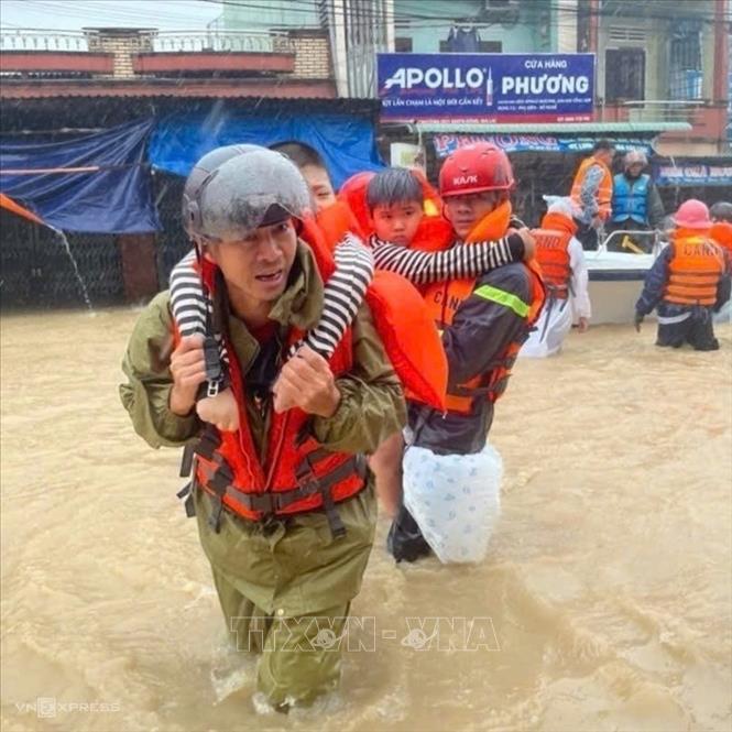  Bộ đội Biên phòng Gia Lai giúp dân sơ tán người già, trẻ em phường Hoài Nhơn Đông ra khỏi vùng lũ. Ảnh: Nguồn Biên phòng Gia Lai (TTXVN phát)