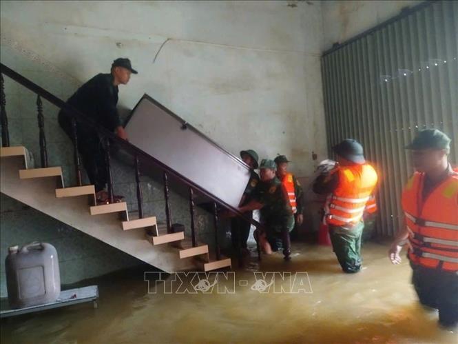 Bộ đội Biên phòng Gia Lai giúp dân phường Hoài Nhơn Đông di chuyển tài sản tránh lũ.  Ảnh: Nguồn Biên phòng Gia Lai (TTXVN phát)
