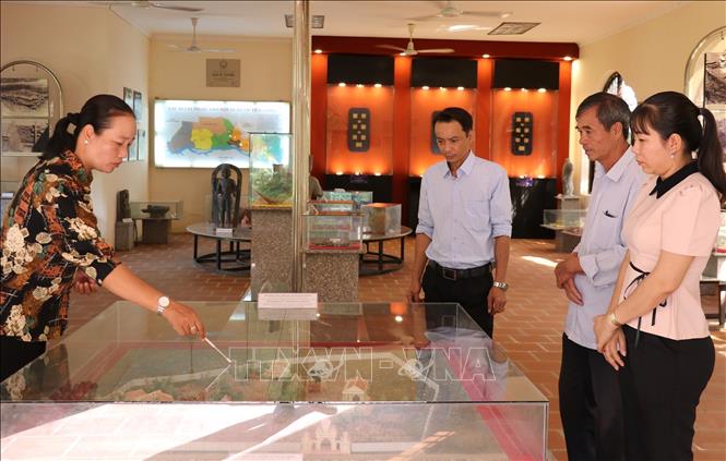 Du khách nghe thuyết minh tại nhà trưng bày di chỉ khảo cổ Gò Thành, xã Tân Thuận Bình, tỉnh Đồng Tháp. Ảnh: Hữu Chí – TTXVN 