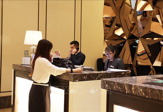 Khách check-in tại quầy lễ tân khách sạn Caravelle Saigon. Ảnh: Hồng Đạt - TTXVN 
