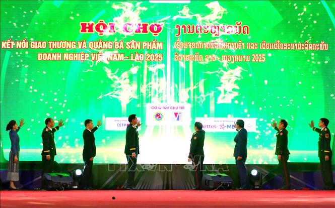 Các đại biểu hai nước Việt Nam - Lào nhấn nút khai mạc Hội chợ. Ảnh: Xuân Tú - PV TTXVN tại Lào