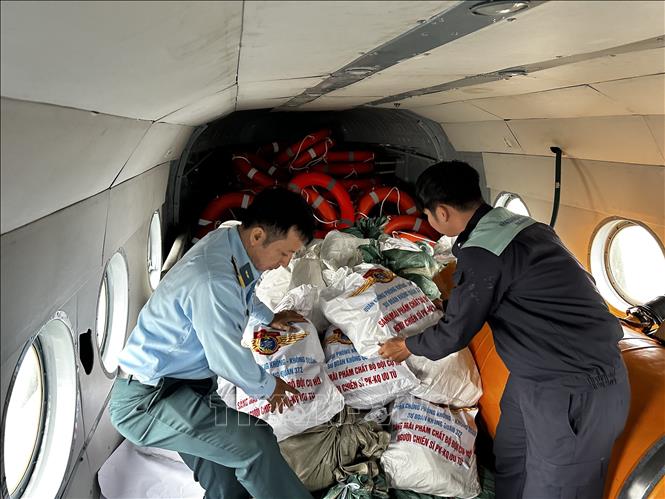 Cán bộ, chiến sĩ Trung đoàn Không quân 930 (Sư đoàn Không quân 372) xếp các bao tải hàng cứu trợ lên máy bay trực thăng để chuyển đến cho người dân đang bị nước lũ bao vây cô lập tại các tỉnh Nam Trung Bộ. Ảnh: Trần Lê Lâm - TTXVN 