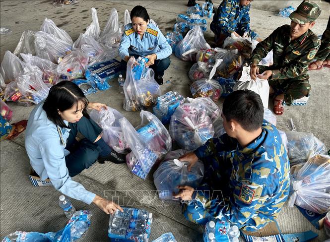 Cán bộ, chiến sĩ Trung đoàn Không quân 930 (Sư đoàn Không quân 372) tiếp tục chuẩn bị hàng nghìn suất quà cứu trợ để chuyển đến cho người dân đang bị nước lũ bao vây cô lập tại các tỉnh Nam Trung Bộ. Ảnh: Trần Lê Lâm - TTXVN 