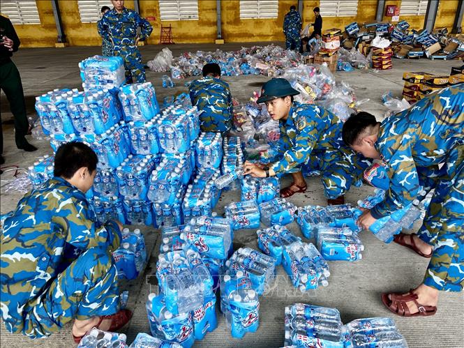 Hàng nghìn suất quà cứu trợ được tiếp tục khẩn trương đóng gói để chuyển lên trực thăng vận chuyển cứu trợ cho người dân đang bị nước lũ bao vây cô lập tại các tỉnh Nam Trung Bộ. Ảnh: Trần Lê Lâm - TTXVN 