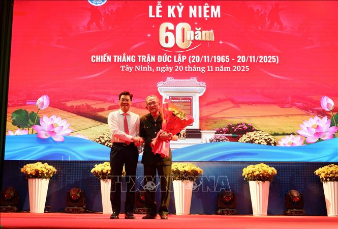 Phó Bí thư Thường trực Tỉnh ủy Tây Ninh Nguyễn Mạnh Hùng tặng hoa cho đồng chí Nguyễn Thanh Tuấn, nguyên Phó Bí thư Tỉnh ủy, nguyên Chủ tịch UBND tỉnh Long An, người trực tiếp tham gia trận đánh Đức Lập năm xưa. Ảnh: Đức Hạnh - TTXVN