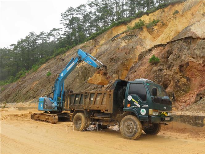 Lực lượng chức năng đang khẩn trương xử lý các điểm sạt lở trên Quốc lộ 24. Ảnh: Dư Toán - TTXVN
